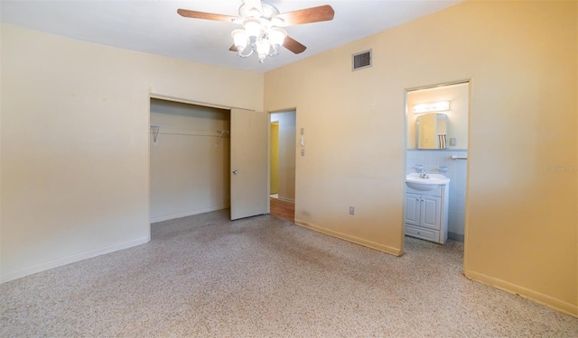 unfurnished bedroom with light carpet, a closet, connected bathroom, and ceiling fan