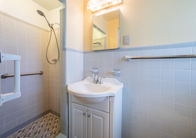 bathroom with vanity, tile walls, and tiled shower