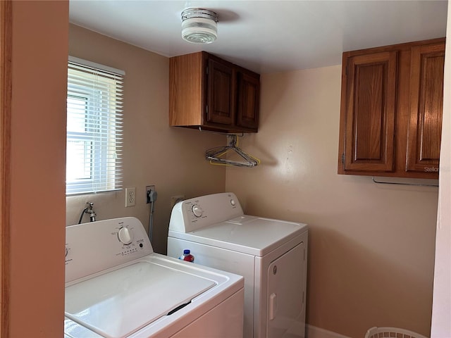 laundry area featuring separate washer and dryer and cabinets