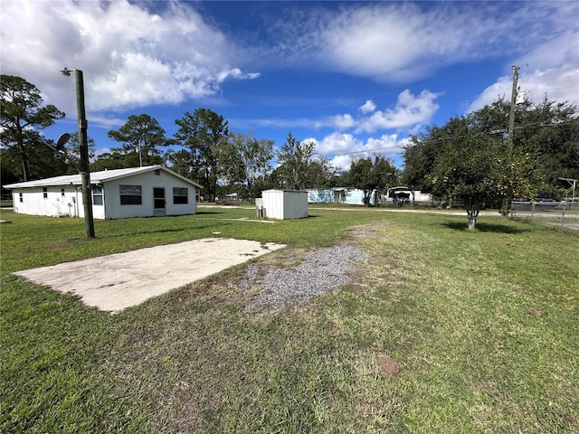 view of yard with fence and an outbuilding