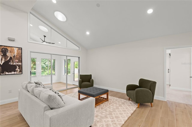 living room featuring light hardwood / wood-style flooring, high vaulted ceiling, and ceiling fan