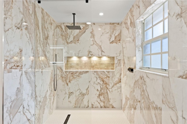 bathroom featuring a healthy amount of sunlight, tile walls, and tiled shower