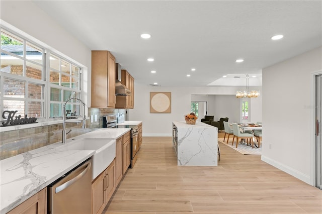 kitchen with light stone countertops, appliances with stainless steel finishes, decorative backsplash, and hanging light fixtures