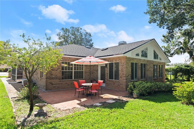 rear view of property featuring a yard and a patio area