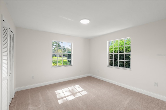 unfurnished bedroom with light carpet and a closet