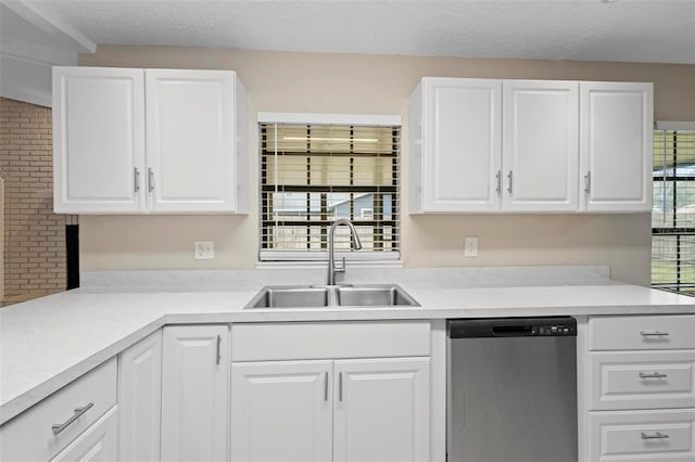 kitchen with dishwasher, white cabinetry, and sink