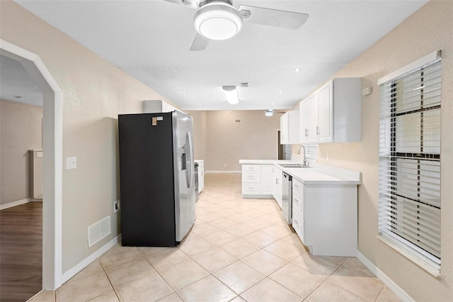 kitchen with a textured ceiling, sink, ceiling fan, white cabinetry, and appliances with stainless steel finishes