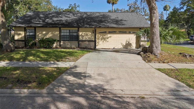 ranch-style house featuring a garage and a front lawn