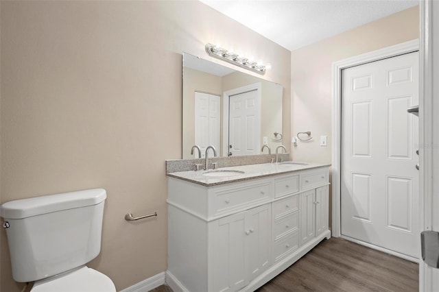 bathroom with hardwood / wood-style flooring, vanity, and toilet