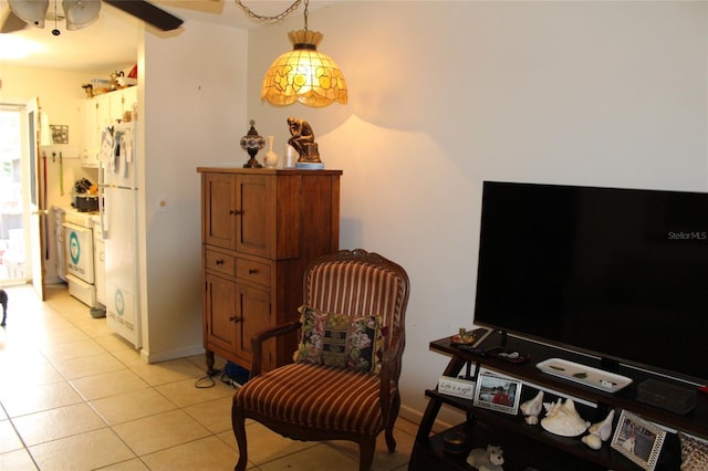 sitting room featuring washer / clothes dryer, light tile patterned floors, and ceiling fan