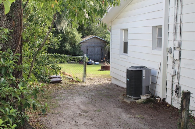 view of yard featuring central air condition unit and a storage shed