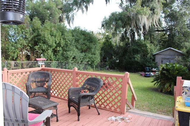 wooden deck with a storage unit and a yard