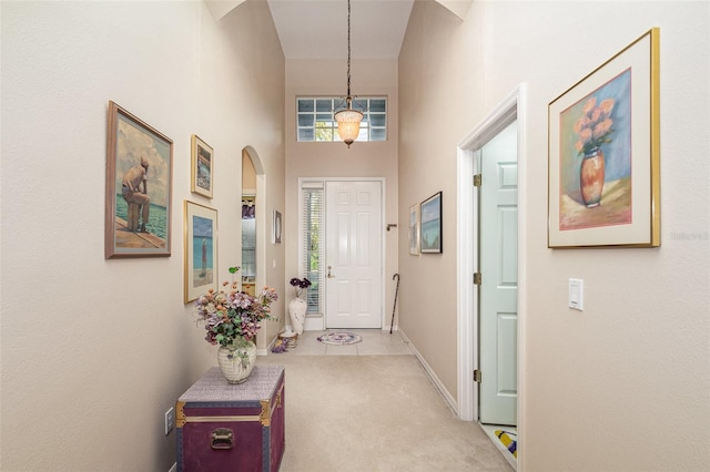 interior space with light carpet and a high ceiling