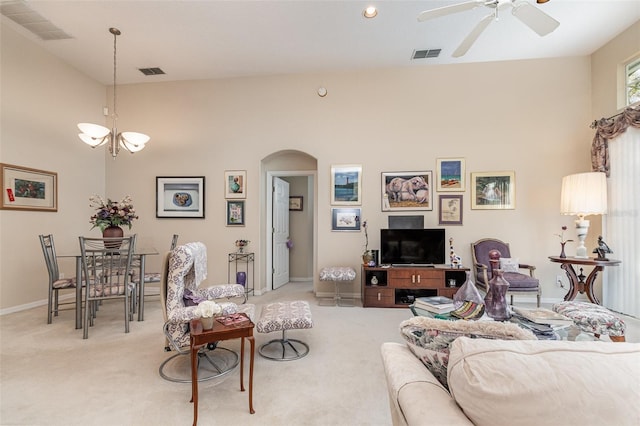 living room featuring light carpet and ceiling fan with notable chandelier