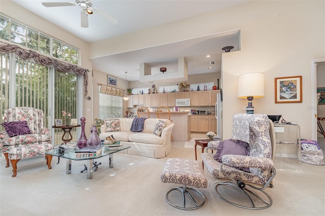 carpeted living room with a high ceiling and ceiling fan