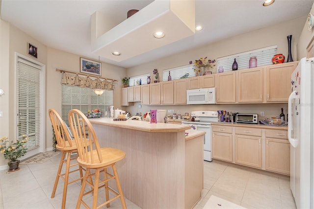 kitchen featuring white appliances, a center island, a kitchen breakfast bar, light tile patterned floors, and light brown cabinets