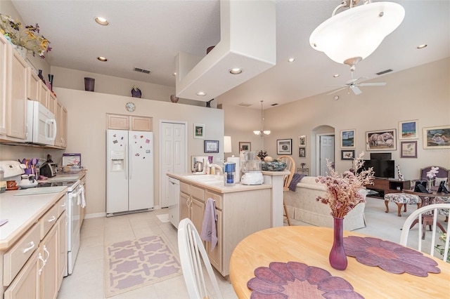 kitchen with hanging light fixtures, a kitchen island, ceiling fan with notable chandelier, sink, and white appliances