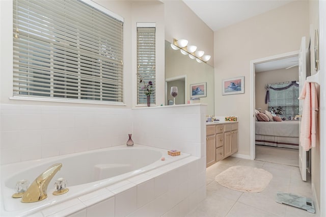 bathroom with vanity, tiled bath, and tile patterned flooring