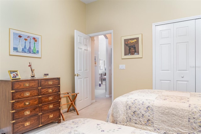 bedroom featuring light colored carpet and a closet