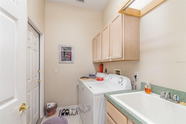 clothes washing area featuring tile patterned floors, sink, independent washer and dryer, and cabinets