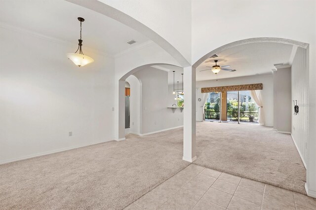 carpeted spare room featuring ceiling fan and crown molding