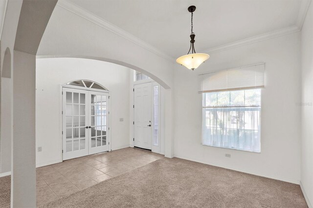 foyer featuring light tile patterned flooring, ornamental molding, and french doors