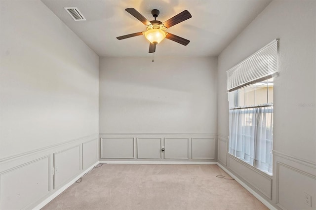 spare room with ceiling fan and light colored carpet