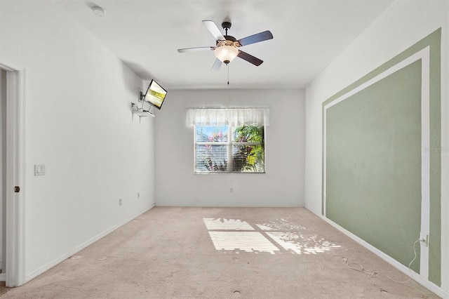 spare room featuring ceiling fan and light colored carpet