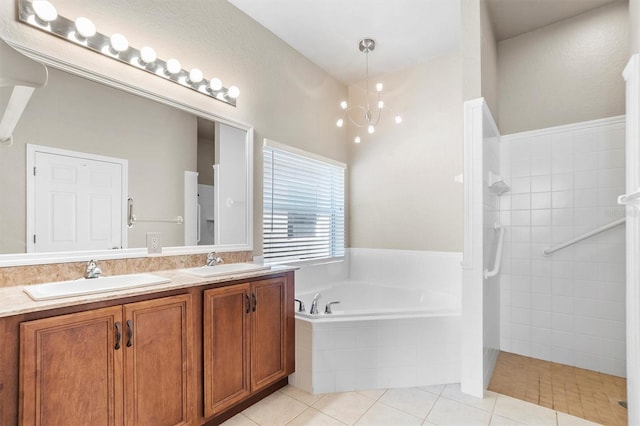 bathroom with tile patterned floors, vanity, separate shower and tub, and an inviting chandelier