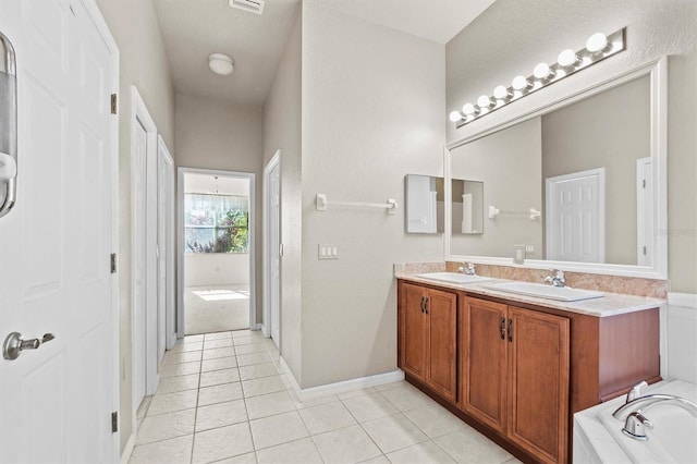 bathroom featuring tile patterned flooring, vanity, and a tub