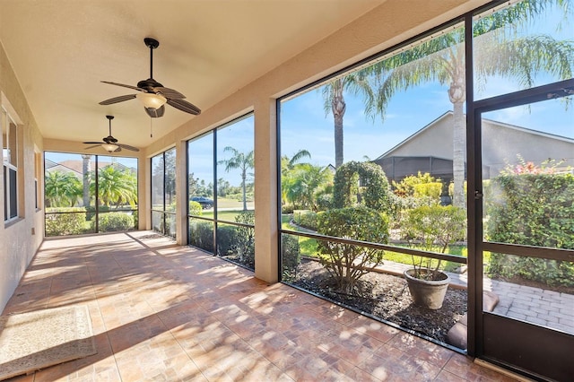 unfurnished sunroom featuring ceiling fan