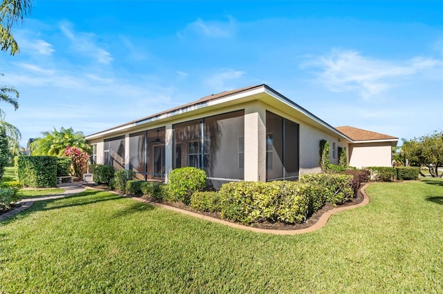 back of property featuring a lawn and a sunroom