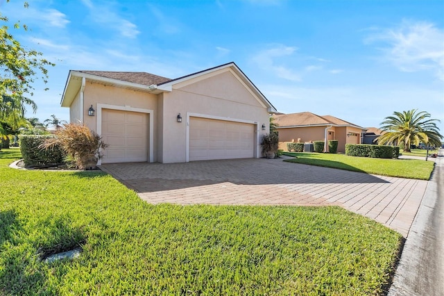 single story home with central air condition unit, a front lawn, and a garage