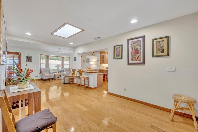 living room featuring ceiling fan and light hardwood / wood-style flooring