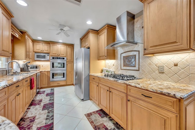 kitchen with ceiling fan, sink, wall chimney exhaust hood, stainless steel appliances, and light tile patterned floors