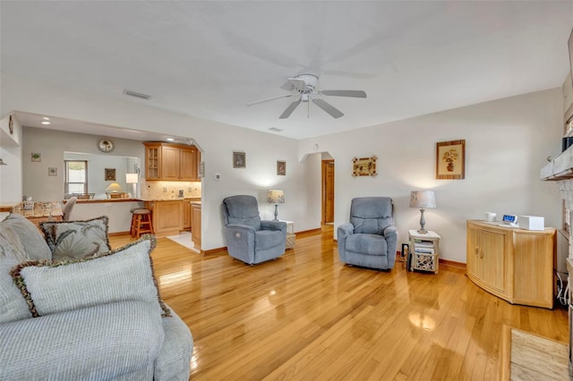 living room with ceiling fan and light hardwood / wood-style floors