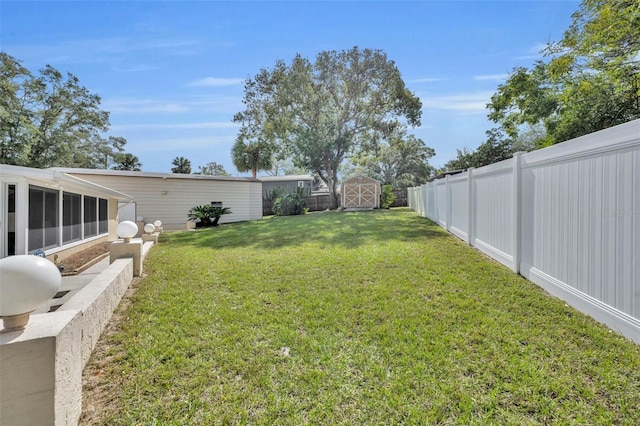 view of yard featuring a sunroom and a shed