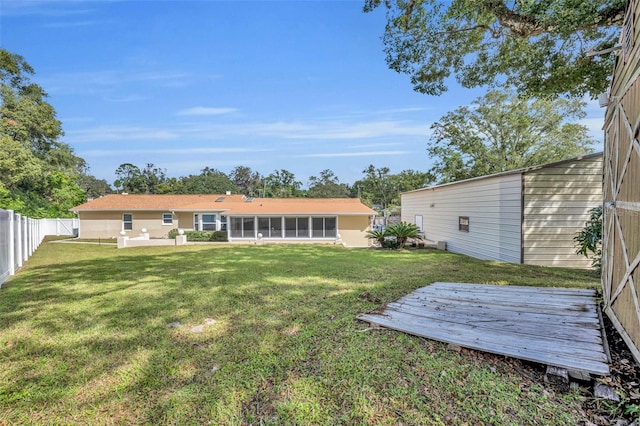 rear view of property featuring a yard and a sunroom