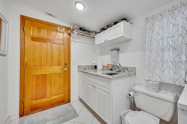 bathroom featuring lofted ceiling, toilet, vanity, visible vents, and tile patterned floors