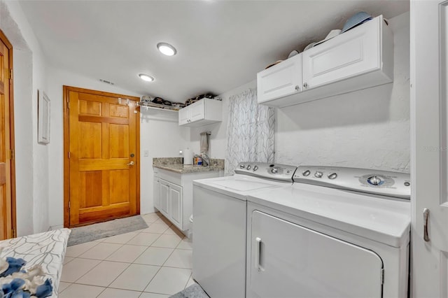 clothes washing area with visible vents, light tile patterned flooring, cabinet space, and washer and dryer