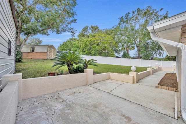 view of patio / terrace featuring an outbuilding, a fenced backyard, and a storage unit