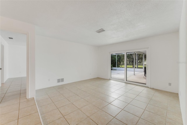 tiled empty room with a textured ceiling