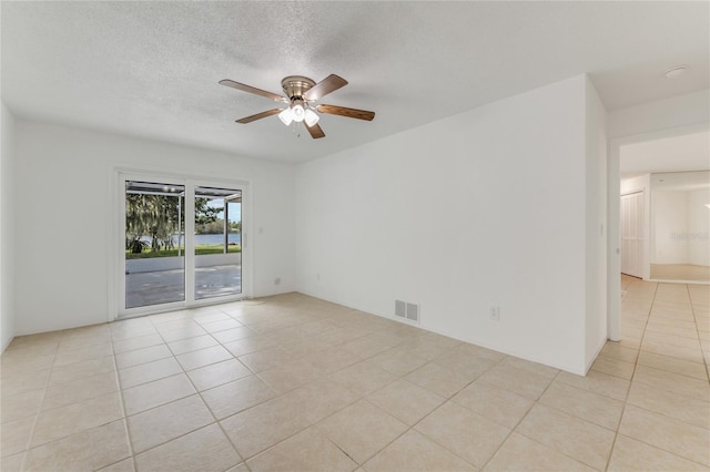 tiled spare room featuring ceiling fan and a textured ceiling