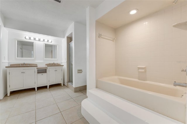 bathroom featuring vanity, tile patterned floors, and tiled shower / bath