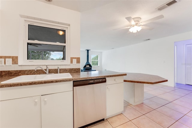 660 Saxon Blvd, Deltona, FL 32725 - kitchen with stainless steel dishwasher, a sink, light tile patterned floors, and white cabinets