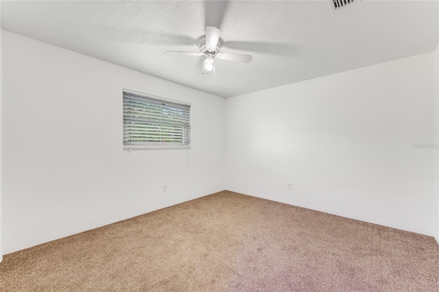 unfurnished room with a textured ceiling, carpet, and ceiling fan