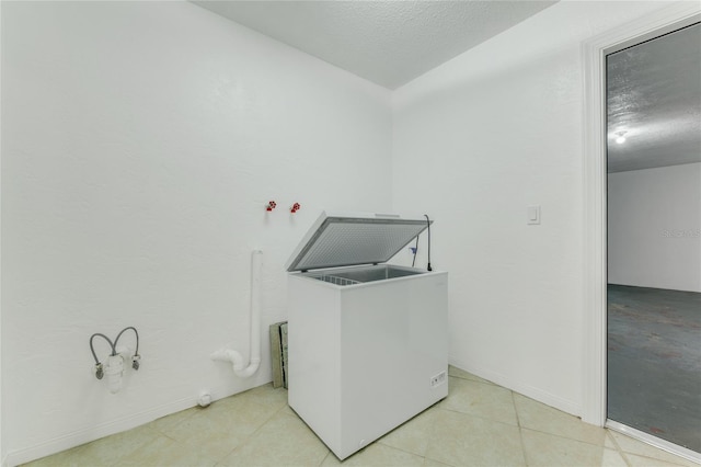 660 Saxon Blvd, Deltona, FL 32725 - washroom with a textured ceiling, baseboards, and light tile patterned flooring