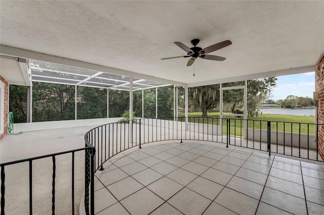 sunroom / solarium featuring ceiling fan and a water view