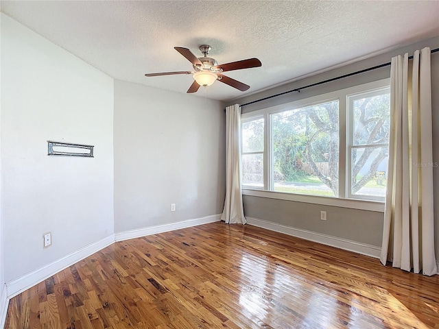 empty room featuring light hardwood / wood-style flooring, a textured ceiling, a healthy amount of sunlight, and ceiling fan