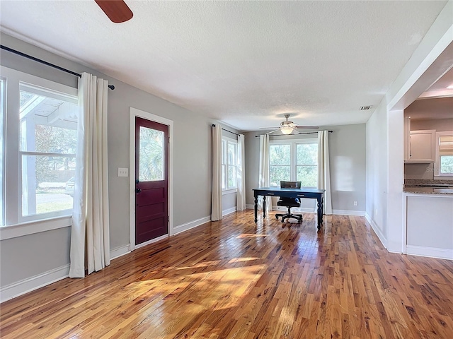 entrance foyer with ceiling fan, a textured ceiling, and light hardwood / wood-style flooring